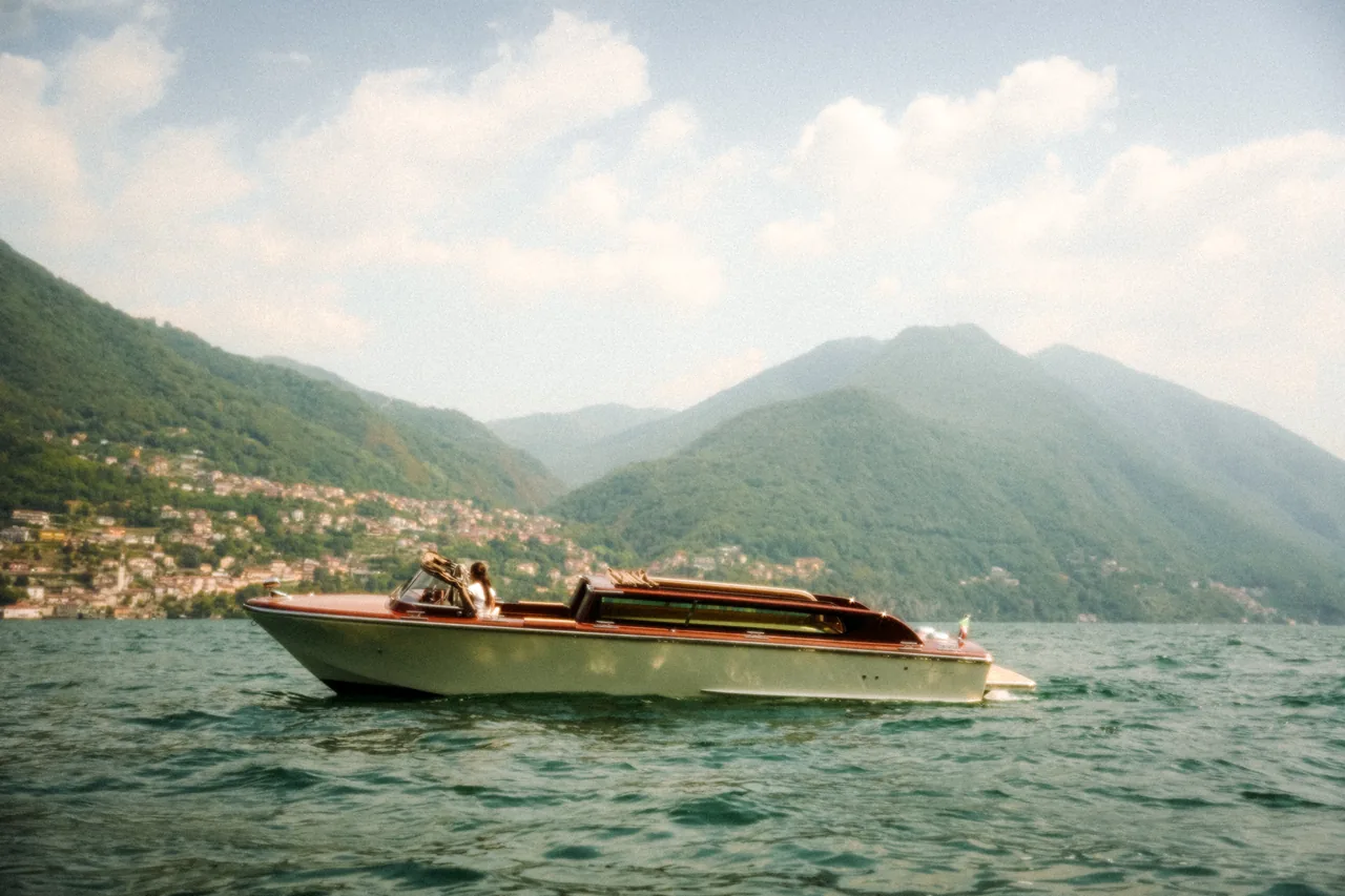 Full side profile of a wooden Venetian taxi boat on Lake Como, from bow to stern.