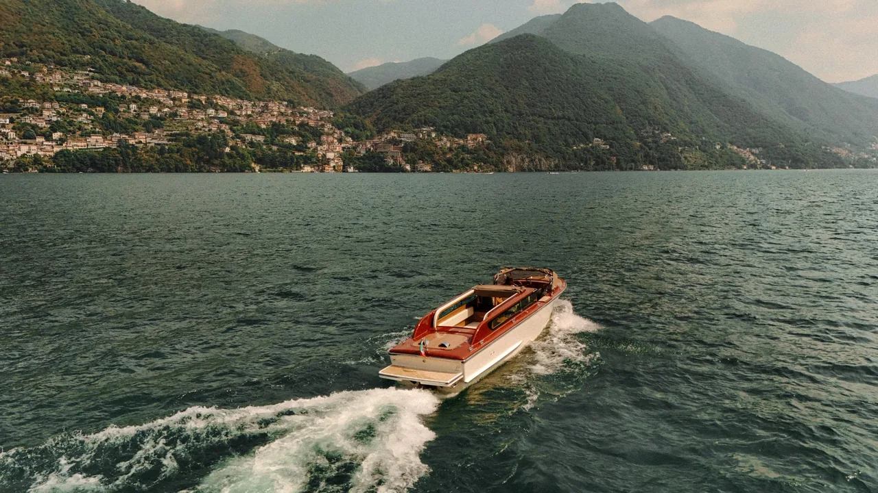 The boat on Lake Como with the mountains and the villages of the shore behind it.